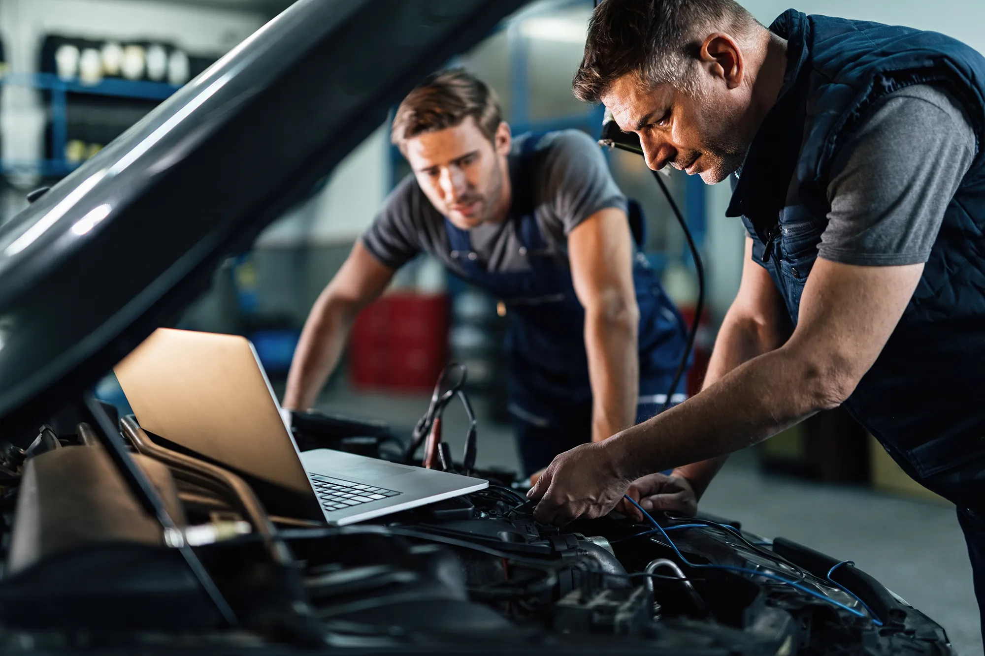 Technicians working on a hybrid car with diagnostic equipment at Royal Automotive in Epping