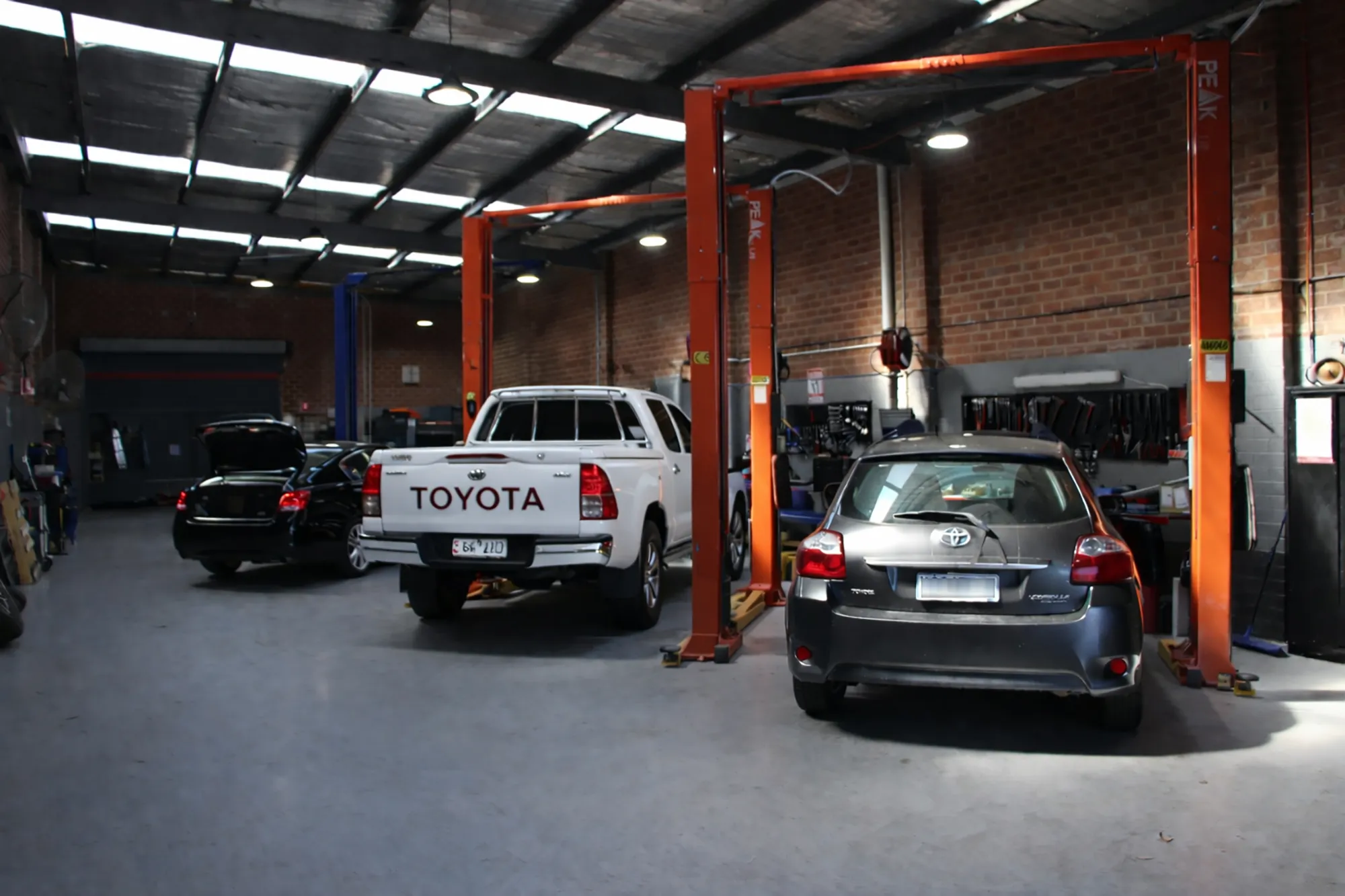Cars on the hoist in the Royal Automotive workshop during a car service in Epping